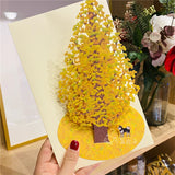3d pop up greeting card of a japanese shiba inu standing under a big ginkgo tree held by a womans hand