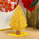 3d pop up greeting card of a japanese shiba inu standing under a big ginkgo tree displayed on a wooden desk