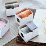 several washi tape sets placed on a closed notebook on a desk