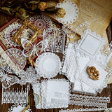 various scrapbooking ephemera paper pack displayed on a vintage table with dried flowers and books