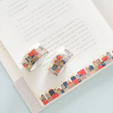 two rolls of gold foiled top quality washi tape displayed on an open book