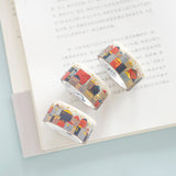 three rolls of gold foiled top quality washi tape displayed on an open book