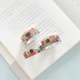 two rolls of gold foiled top quality washi tape displayed on an open book with one of them stretched out