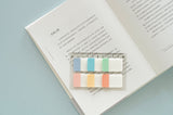 a sticky notes ruler displayed on an open book