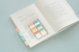 a sticky notes ruler displayed on an open book with some sticky notes applied on the page