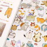 a sheet of cute cat deco stickers displayed next to an open notebook