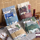 four sets of scrapbooking ephemera paper packs displayed over a white tea towel