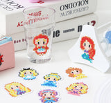 various dotted diamond arts of disney princesses displayed on a white surface two of the diamond arts are attached to everyday objects like glasses and pencil bags