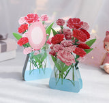 two 3d pop up greeting cards of carnations displayed next to each other on a desk