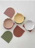 three colour silicon placemats displayed on a white surface with bowls on them