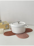 four placemats displayed on a white surface with a white pot on them